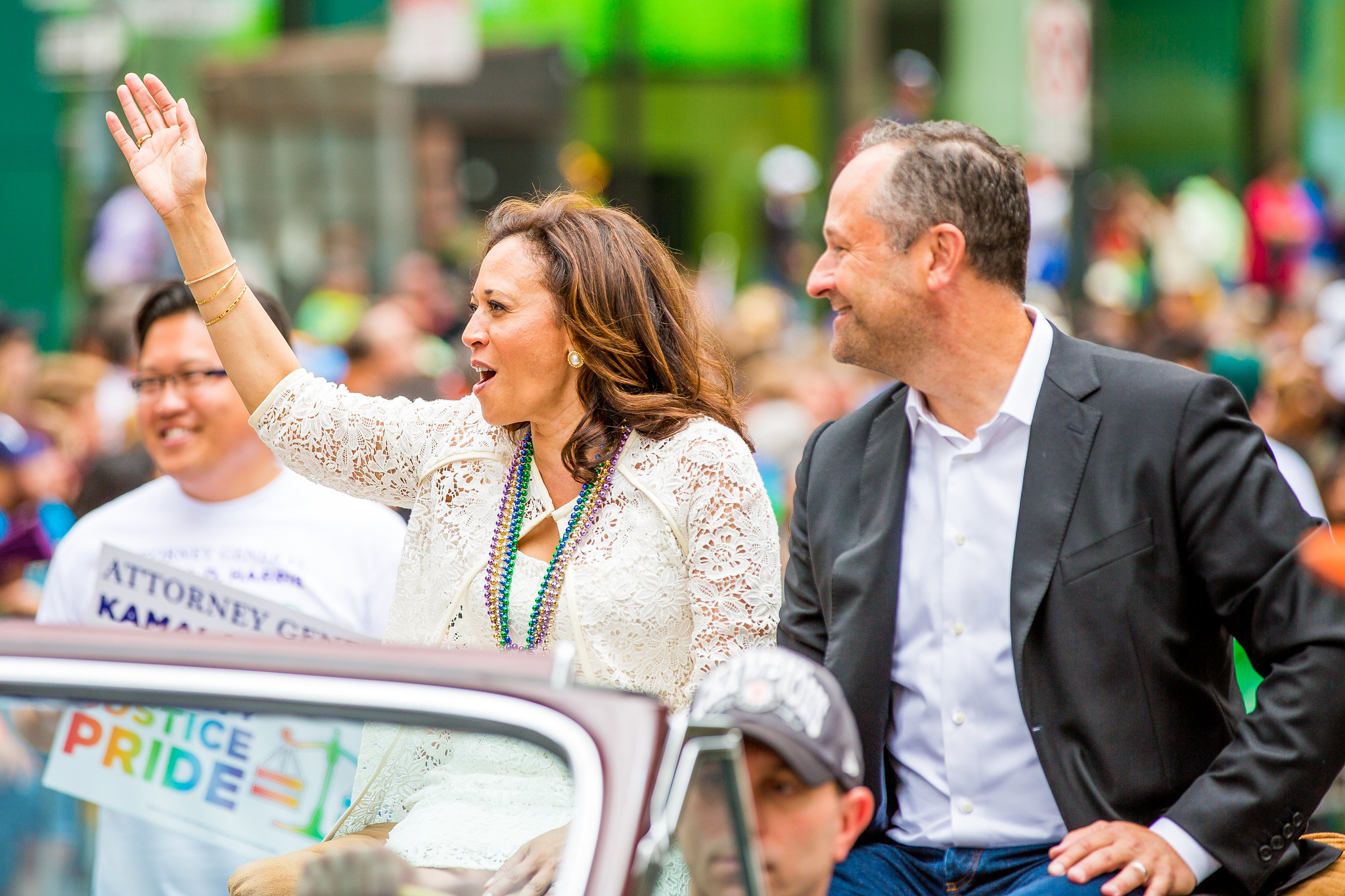Kamala Harris y su marido, Douglas Emhoff, saludan a la multitud desde un vehículo